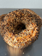 Bagel with garlic, salt, poppy and sesame seeds on it.