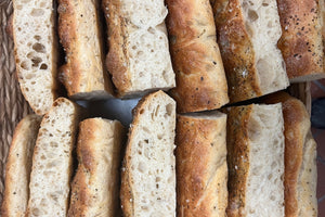 Several slices of focaccia bread with herbs, salt, and olive oil